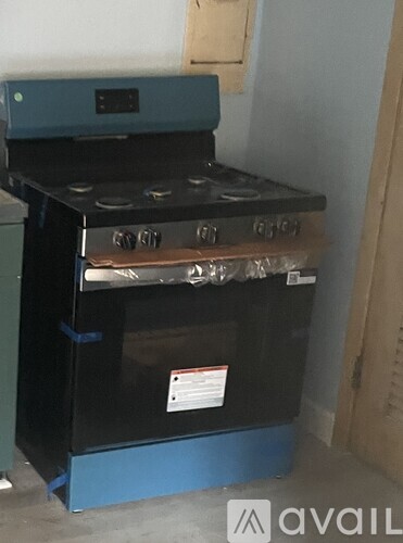 A black and blue stove with a blue base and a sticker on it.