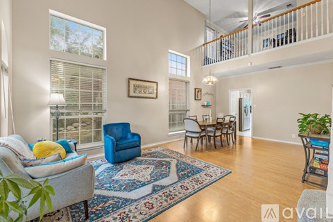 A living room with a blue chair and a rug.