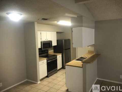 A kitchen with white cabinets and black appliances.