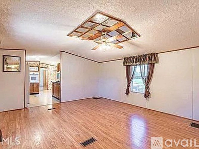 A room with wooden flooring and a ceiling fan.