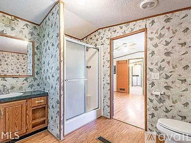 A bathroom with a sink, mirror, and shower.