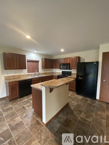 A glass shower stall with a bottle of shampoo on the floor.