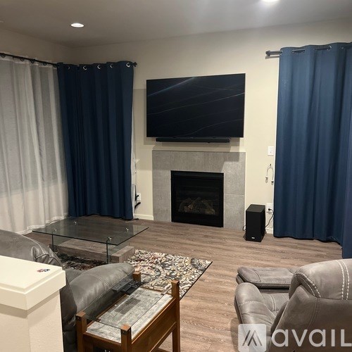 A living room with a fireplace, a television, and a glass coffee table.