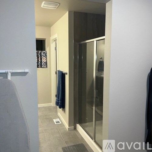 A bathroom with a glass shower door and a towel hanging on the door.