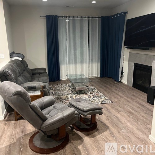 A living room with a grey leather chair and a glass coffee table.