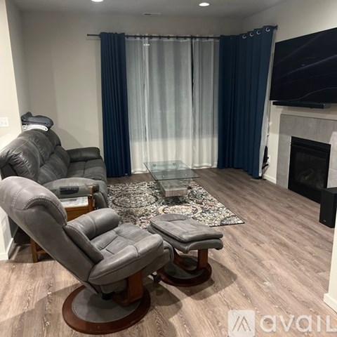 A living room with a grey leather chair and a glass coffee table.