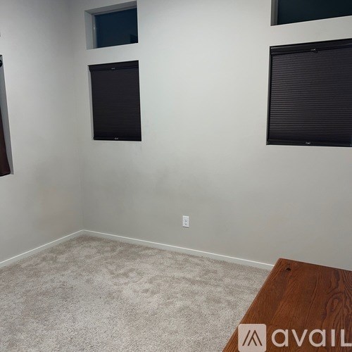 A room with a carpeted floor and a wooden table.