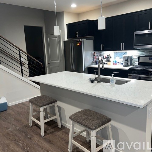 A kitchen with a white countertop and a stainless steel refrigerator.