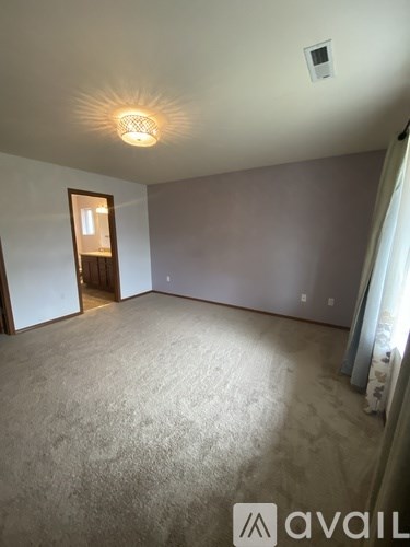 A bedroom with a bed, dresser, and mirror.
