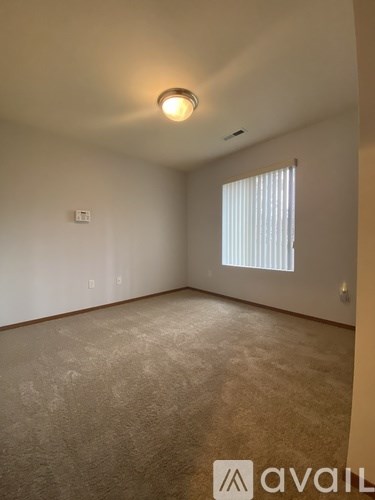 A bedroom with a bed, nightstand, and lamp.