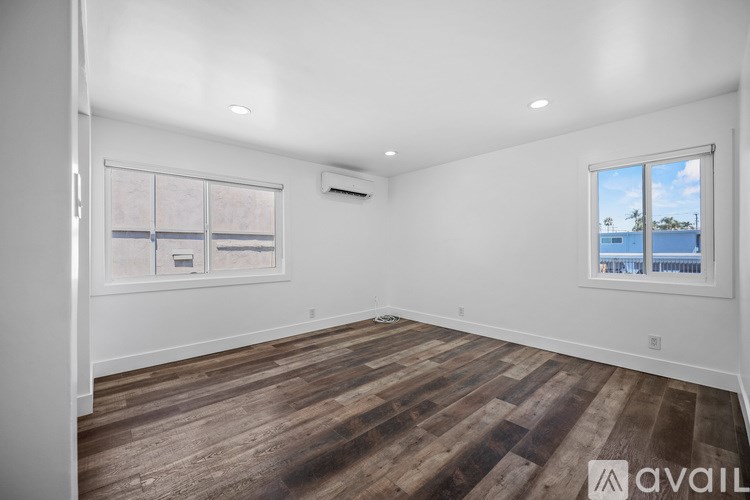 A room with wooden flooring and a window overlooking a body of water.