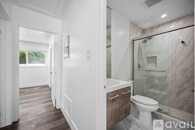 A bathroom with a toilet, sink, and shower.