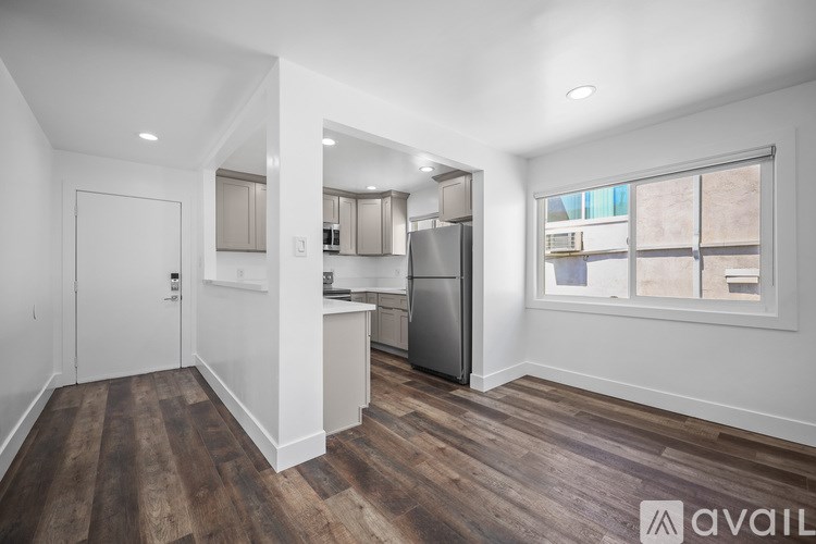 A kitchen with wooden floors and white walls.