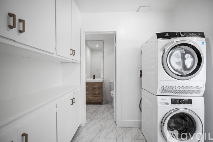 A stack of two washing machines in a laundry room.