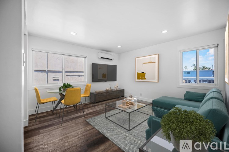 A living room with a grey sofa, yellow chairs, and a glass coffee table.