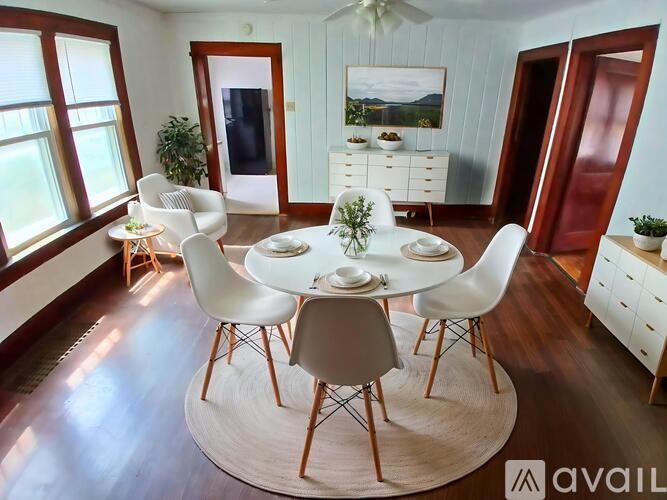 A dining room with a white table and chairs.