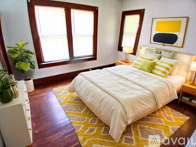 A bedroom with a large bed and a yellow rug.