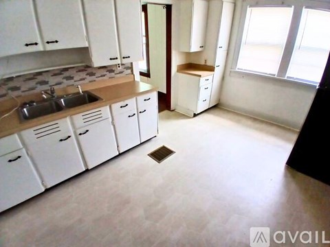 A kitchen with white cabinets and a sink.