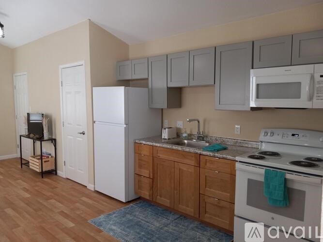 A kitchen with white appliances and wooden cabinets.