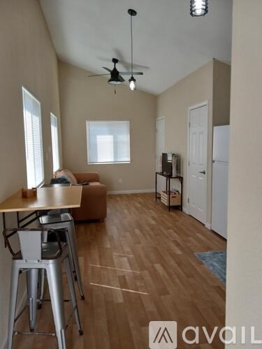 A living room with a brown couch and a wooden floor.