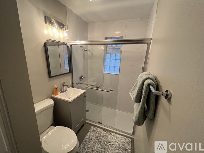 A bathroom with a toilet, sink, and shower.