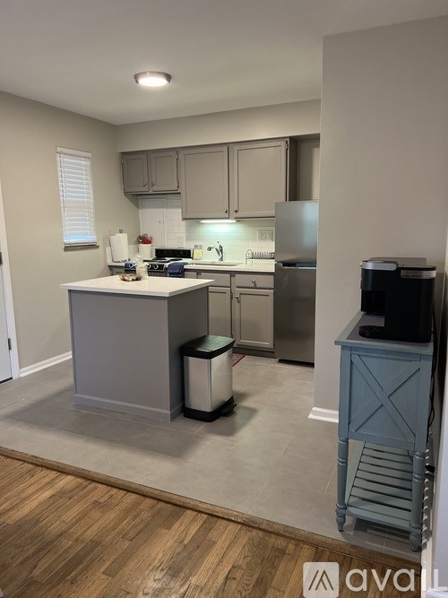 A kitchen with a white countertop and a stainless steel refrigerator.