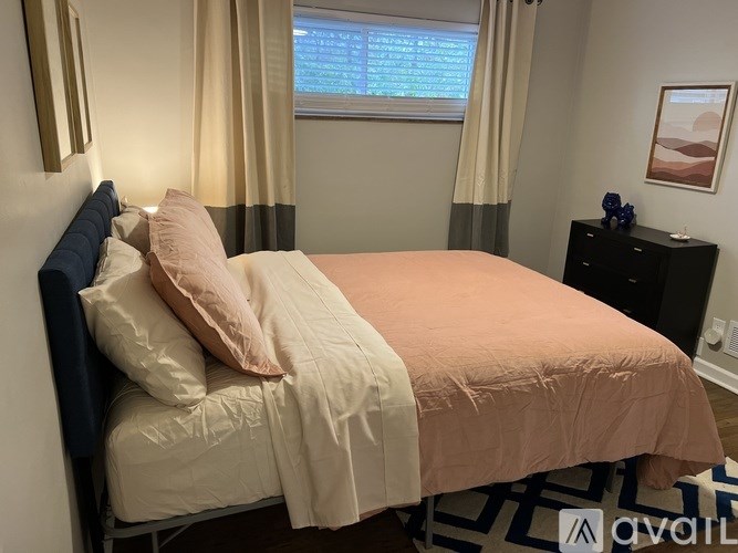 A bed with a blue headboard and a pink blanket.