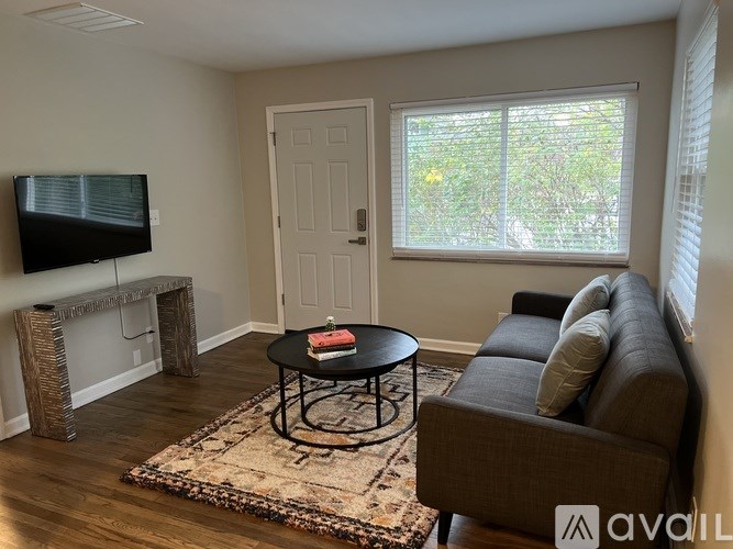 A living room with a couch, a table, and a television.