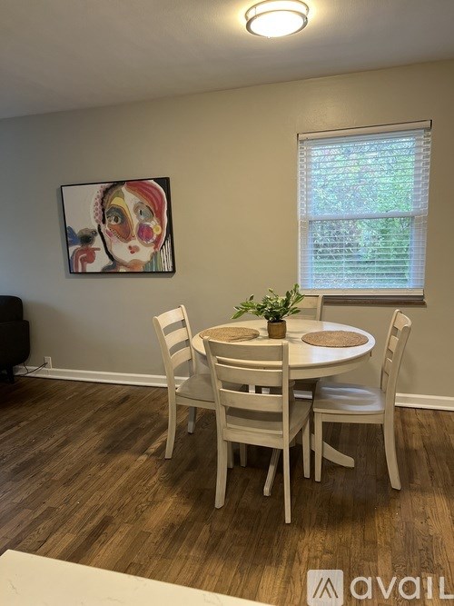 A dining room with a white table and chairs.
