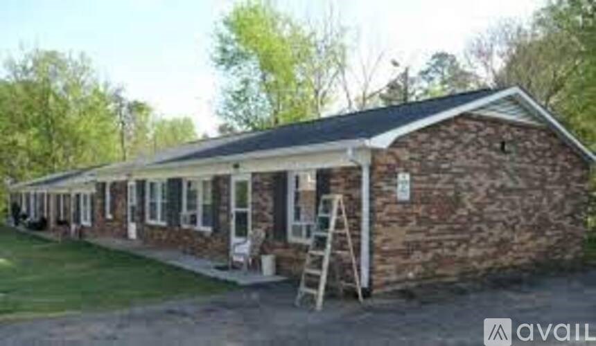 A brick house with a porch and a ladder on the front.