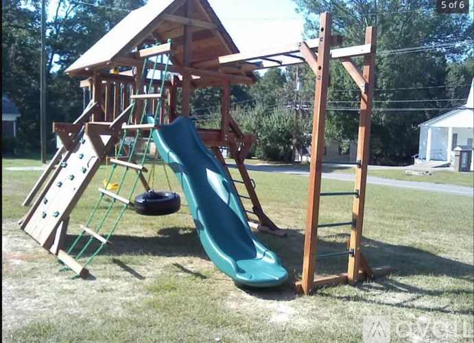 A wooden playground structure with a green slide.