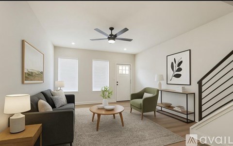 A living room with a couch, chair, and a table with a lamp on it.