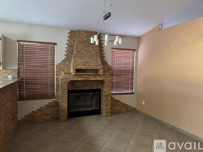 A room with a stone fireplace and a flat screen TV mounted on the wall.
