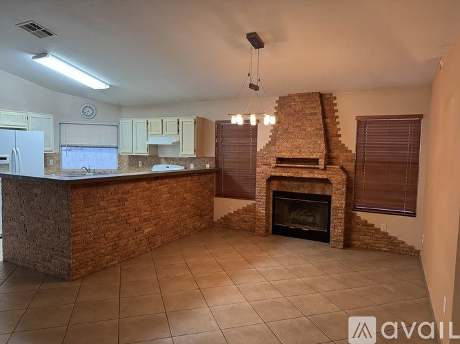 A kitchen with a brick fireplace and a tiled floor.