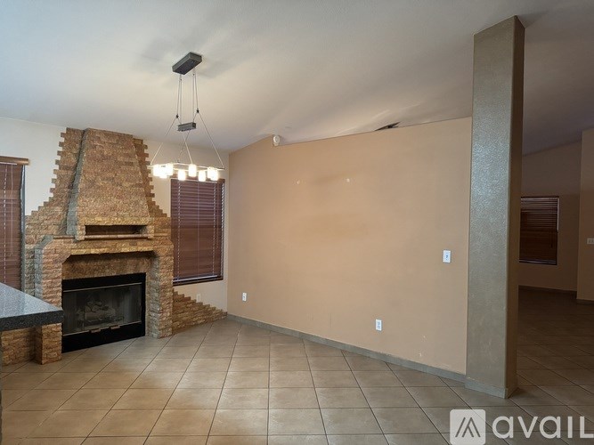 A living room with a fireplace and a large empty wall.