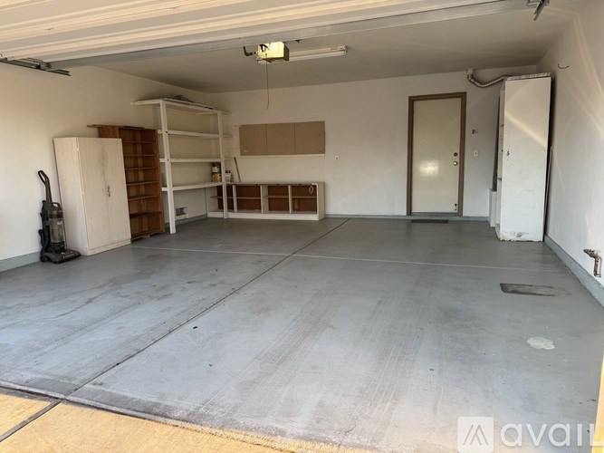 A large, empty room with a concrete floor and white walls.