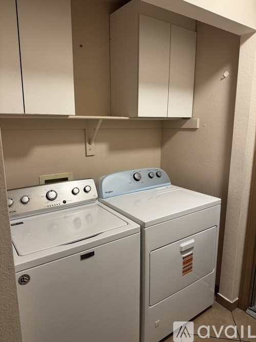 A white washing machine and dryer in a small laundry room.