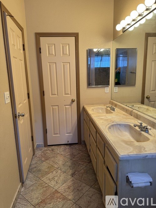 A bathroom with a sink, mirror, and two doors.