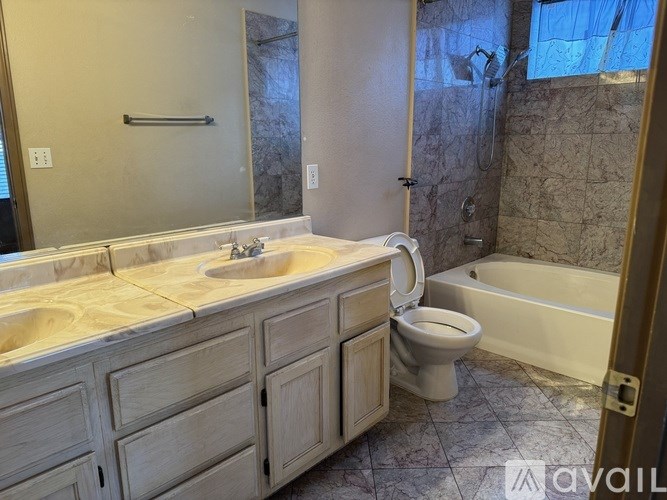 A bathroom with a toilet, sink, and bathtub.