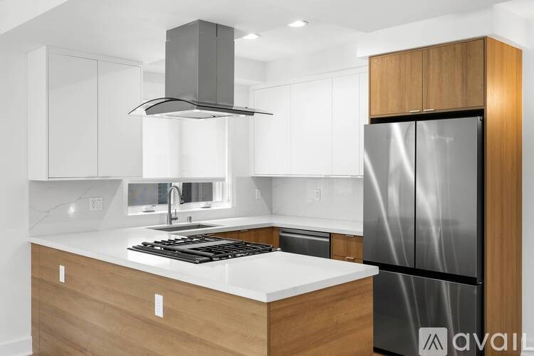 A modern kitchen with a stainless steel refrigerator and wooden cabinets.