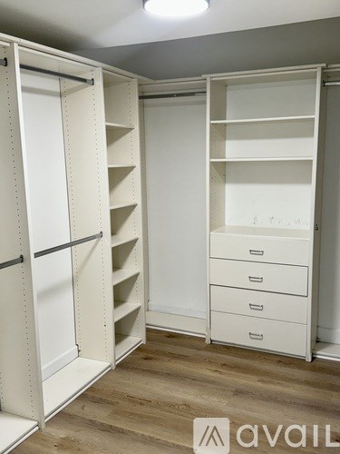 A white walk-in closet with shelves and drawers.