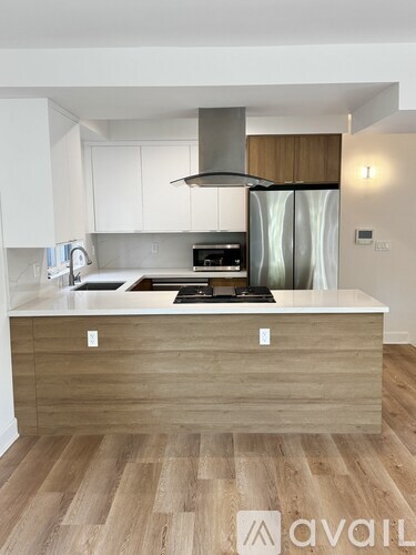 A modern kitchen with a wooden island and stainless steel appliances.