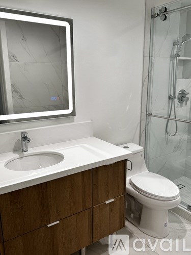 A modern bathroom with a white sink and a white toilet.