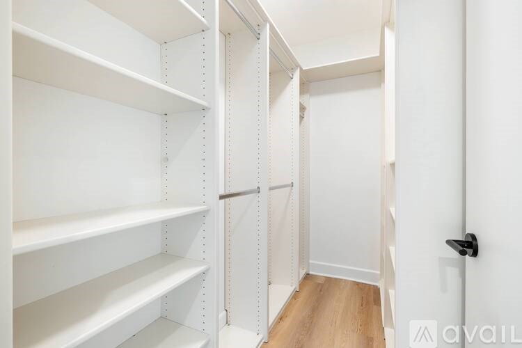 A white pantry with shelves and a door.