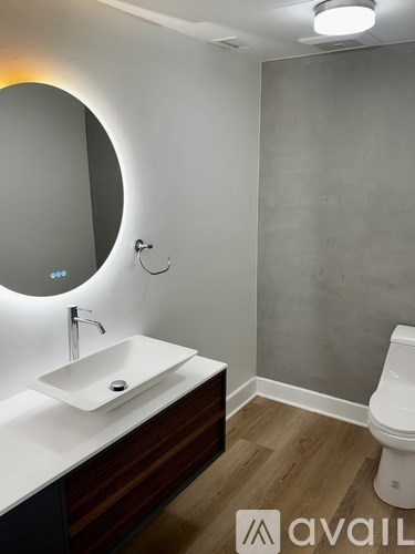 A bathroom with a round mirror and a sink.