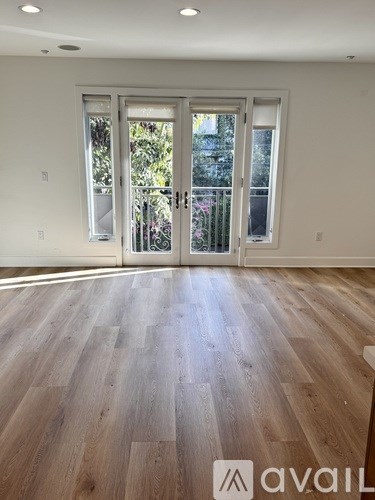 A room with wooden flooring and a large door.