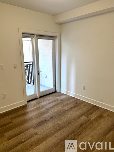 A room with wooden flooring and a sliding glass door.