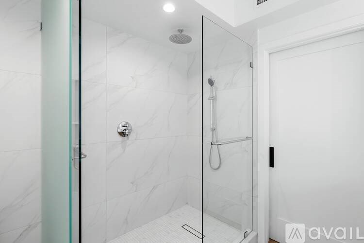 A white bathroom with a glass shower door.