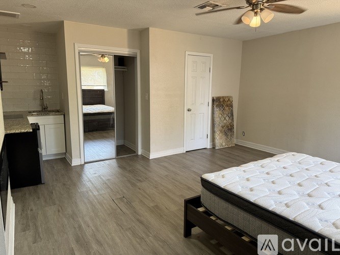 A bedroom with a bed, dresser, and a ceiling fan.