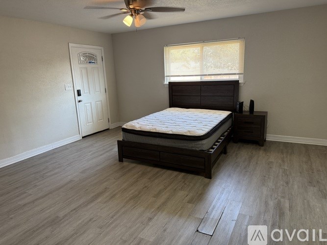 A bedroom with a bed, dresser, and window.